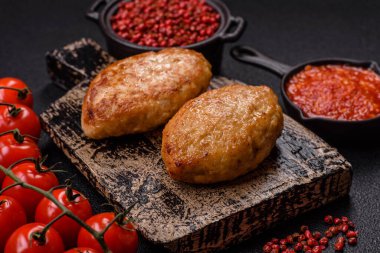 Lezzetli taze kıymalı balık pirzolası. Esmer arka planda baharatlar ve otlarla birlikte.