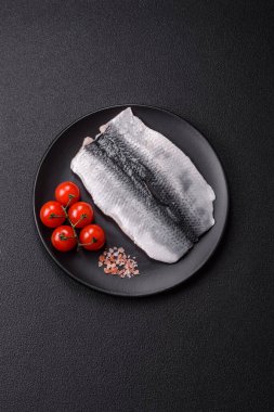 Ringa fileto tuzlu ve tuzlu, baharatlı ve yağlı koyu beton arka planda.