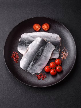 Ringa fileto tuzlu ve tuzlu, baharatlı ve yağlı koyu beton arka planda.