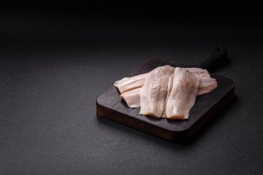 Ringa fileto tuzlu ve tuzlu, baharatlı ve yağlı koyu beton arka planda.