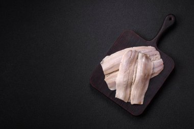 Ringa fileto tuzlu ve tuzlu, baharatlı ve yağlı koyu beton arka planda.