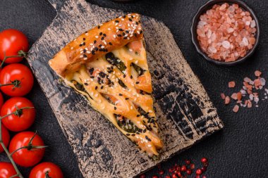 Somon, ıspanak ya da brokoli, tuz ve baharatlı kiş parçaları koyu beton arka planda.