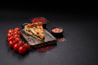 Somon, ıspanak ya da brokoli, tuz ve baharatlı kiş parçaları koyu beton arka planda.