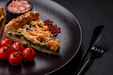 Somon, ıspanak ya da brokoli, tuz ve baharatlı kiş parçaları koyu beton arka planda.