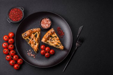 Somon, ıspanak ya da brokoli, tuz ve baharatlı kiş parçaları koyu beton arka planda.