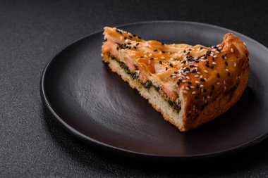 Somon, ıspanak ya da brokoli, tuz ve baharatlı kiş parçaları koyu beton arka planda.