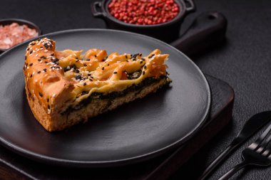 Somon, ıspanak ya da brokoli, tuz ve baharatlı kiş parçaları koyu beton arka planda.