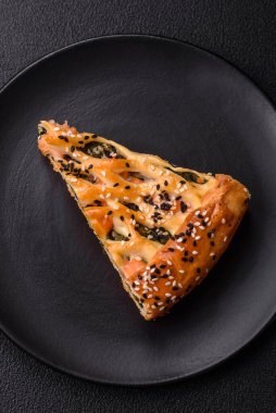 Somon, ıspanak ya da brokoli, tuz ve baharatlı kiş parçaları koyu beton arka planda.