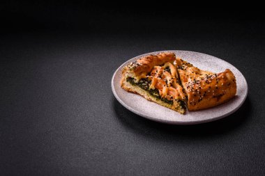 Somon, ıspanak ya da brokoli, tuz ve baharatlı kiş parçaları koyu beton arka planda.