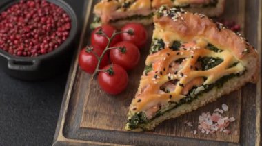 Somon, ıspanak ya da brokoli, tuz ve baharatlı kiş parçaları koyu beton arka planda.