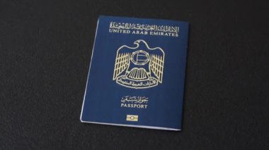 Koyu beton arka planda Birleşik Arap Emirlikleri vatandaşının uluslararası pasaportu.