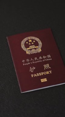 Koyu beton arka planda bir Çin vatandaşının uluslararası pasaportu.