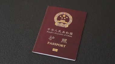 Koyu beton arka planda bir Çin vatandaşının uluslararası pasaportu.