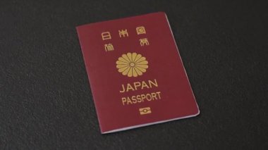 Koyu beton arka planda bir Japon vatandaşının uluslararası pasaportu, uluslararası seyahat