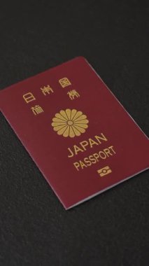 Koyu beton arka planda bir Japon vatandaşının uluslararası pasaportu, uluslararası seyahat