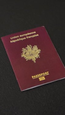 Fransa Cumhuriyeti pasaportu koyu beton arka planda. Turizm ve seyahat teması üzerine kavramsal arka plan