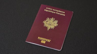 Fransa Cumhuriyeti pasaportu koyu beton arka planda. Turizm ve seyahat teması üzerine kavramsal arka plan