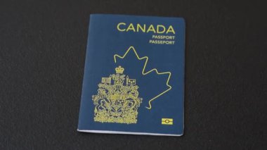 Koyu beton arka planda, uluslararası seyahat yapan bir Kanada vatandaşının uluslararası pasaportu