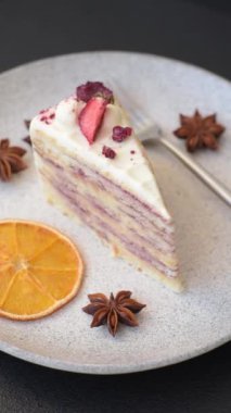 Üzerinde beyaz krema, ahududu ve çilek olan bir dilim tatlı katmanlı pasta.