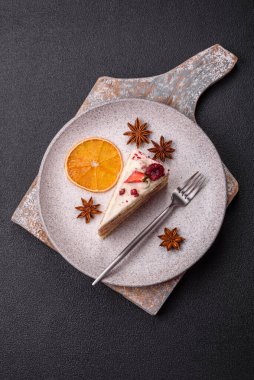 Üzerinde beyaz krema, ahududu ve çilek olan bir dilim tatlı katmanlı pasta.