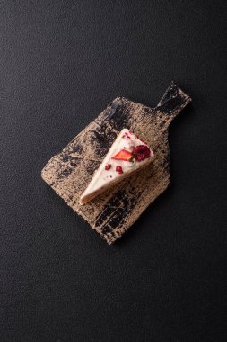 Üzerinde beyaz krema, ahududu ve çilek olan bir dilim tatlı katmanlı pasta.