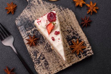 Üzerinde beyaz krema, ahududu ve çilek olan bir dilim tatlı katmanlı pasta.