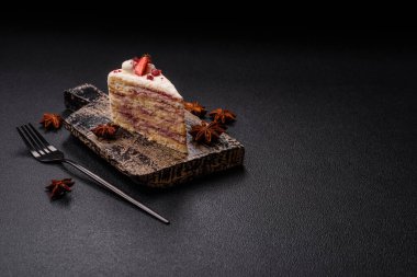 Üzerinde beyaz krema, ahududu ve çilek olan bir dilim tatlı katmanlı pasta.