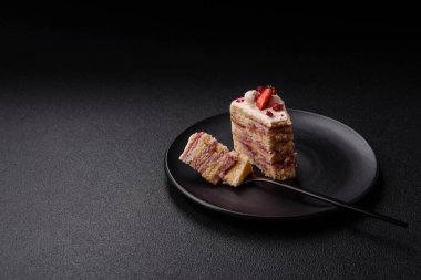 Üzerinde beyaz krema, ahududu ve çilek olan bir dilim tatlı katmanlı pasta.