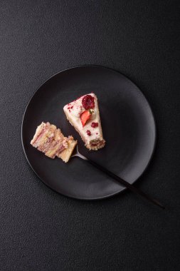 Üzerinde beyaz krema, ahududu ve çilek olan bir dilim tatlı katmanlı pasta.