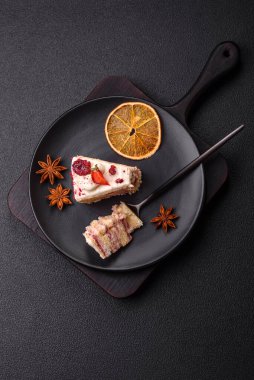 Üzerinde beyaz krema, ahududu ve çilek olan bir dilim tatlı katmanlı pasta.