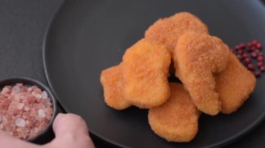 Delicious fresh crispy chicken nuggets on a dark concrete background. Unhealthy food, fast food