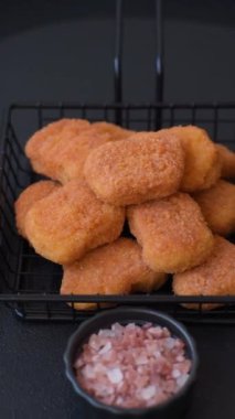 Delicious fresh crispy chicken nuggets on a dark concrete background. Unhealthy food, fast food