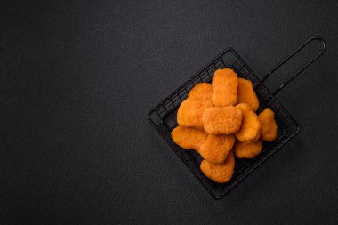 Delicious fresh crispy chicken nuggets on a dark concrete background. Unhealthy food, fast food