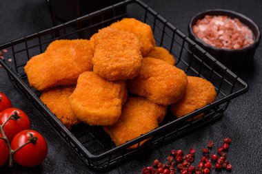 Delicious fresh crispy chicken nuggets on a dark concrete background. Unhealthy food, fast food