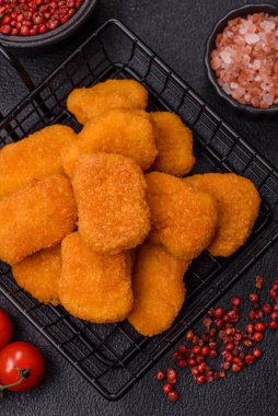 Delicious fresh crispy chicken nuggets on a dark concrete background. Unhealthy food, fast food