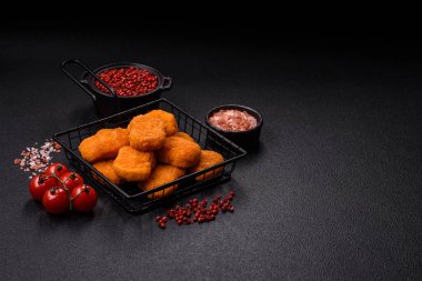 Delicious fresh crispy chicken nuggets on a dark concrete background. Unhealthy food, fast food