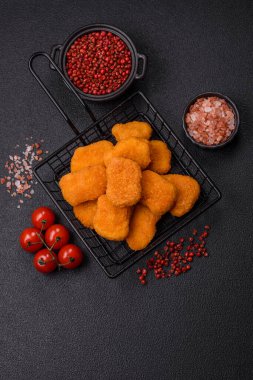 Delicious fresh crispy chicken nuggets on a dark concrete background. Unhealthy food, fast food