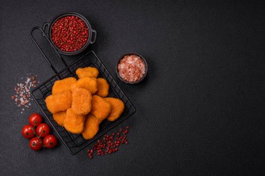 Delicious fresh crispy chicken nuggets on a dark concrete background. Unhealthy food, fast food