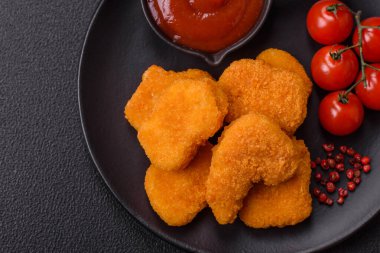 Delicious fresh crispy chicken nuggets on a dark concrete background. Unhealthy food, fast food