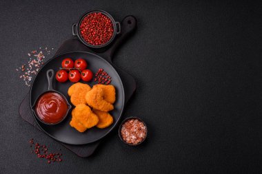 Delicious fresh crispy chicken nuggets on a dark concrete background. Unhealthy food, fast food
