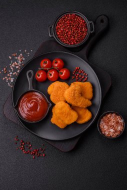 Delicious fresh crispy chicken nuggets on a dark concrete background. Unhealthy food, fast food