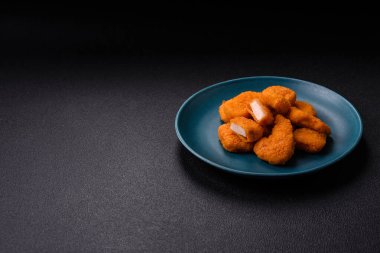 Delicious fresh crispy chicken nuggets on a dark concrete background. Unhealthy food, fast food