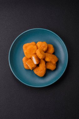 Delicious fresh crispy chicken nuggets on a dark concrete background. Unhealthy food, fast food