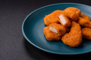 Delicious fresh crispy chicken nuggets on a dark concrete background. Unhealthy food, fast food