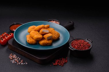 Delicious fresh crispy chicken nuggets on a dark concrete background. Unhealthy food, fast food