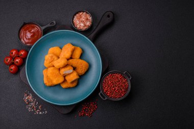 Delicious fresh crispy chicken nuggets on a dark concrete background. Unhealthy food, fast food
