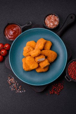 Delicious fresh crispy chicken nuggets on a dark concrete background. Unhealthy food, fast food