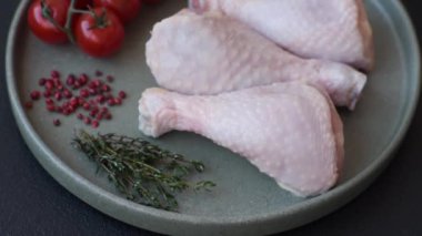 Tuzlu, baharatlı, otlu ve domatesli çiğ tavuk budu.