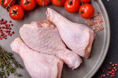 Tuzlu, baharatlı, otlu ve domatesli çiğ tavuk budu.