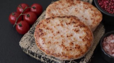 Koyu beton zeminde tuzlu, baharatlı ve otlu ızgara tavuk burgeri.